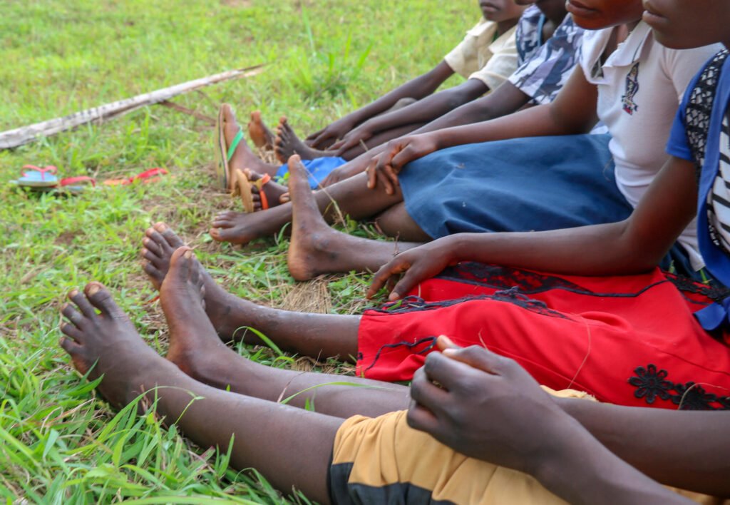 Lähikuva kongolaisten lasten jaloista.