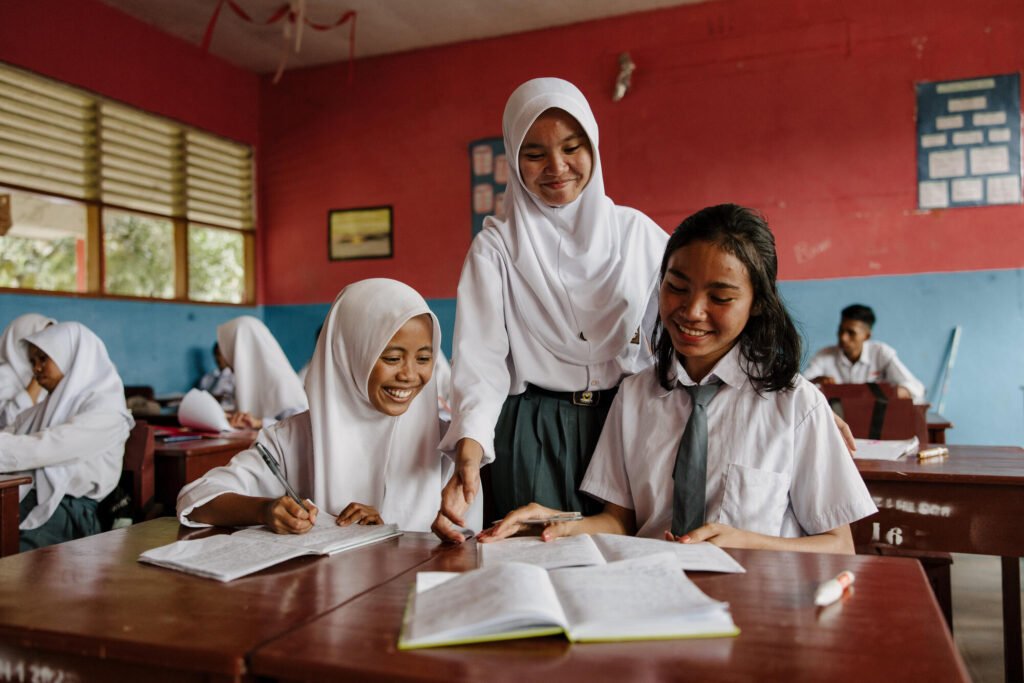 Indonesialainen kummilapsi Tasya hymyilee koulussa koulukavereidensa kanssa.