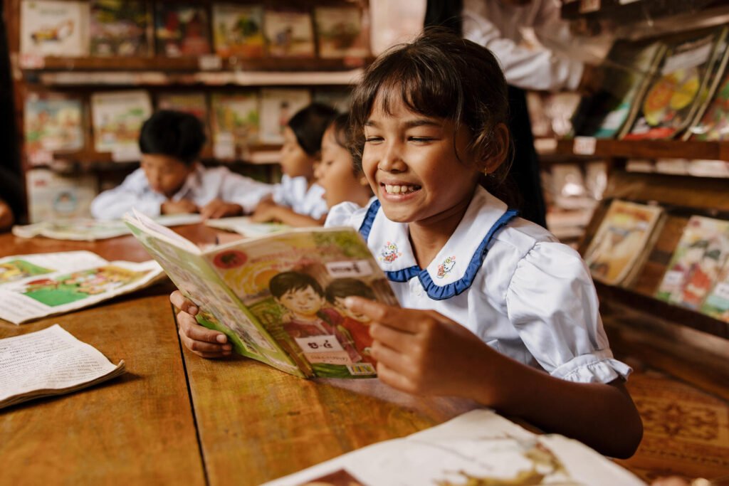 Kambodzalainen koulutyttö lukee kirjaa.