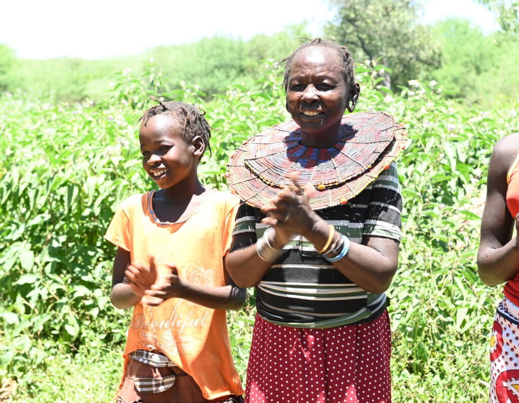 Kenialainen isoäiti, Paka, kahden tyttärentyttären kanssa. Paka kertoo alueen naisille silpomisen vaaroista.