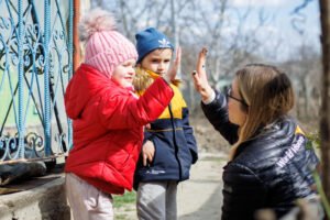 Kaksi ukrainalaista lasta Moldovassa heittää yläfemmat World Visionin työntekijälle.