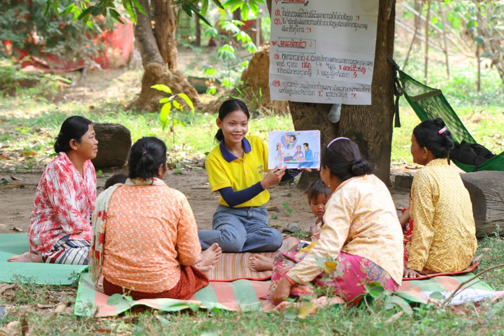 Vapaaehtoinen pitämässä ravitsemuskoulutusta joukolle naisia.