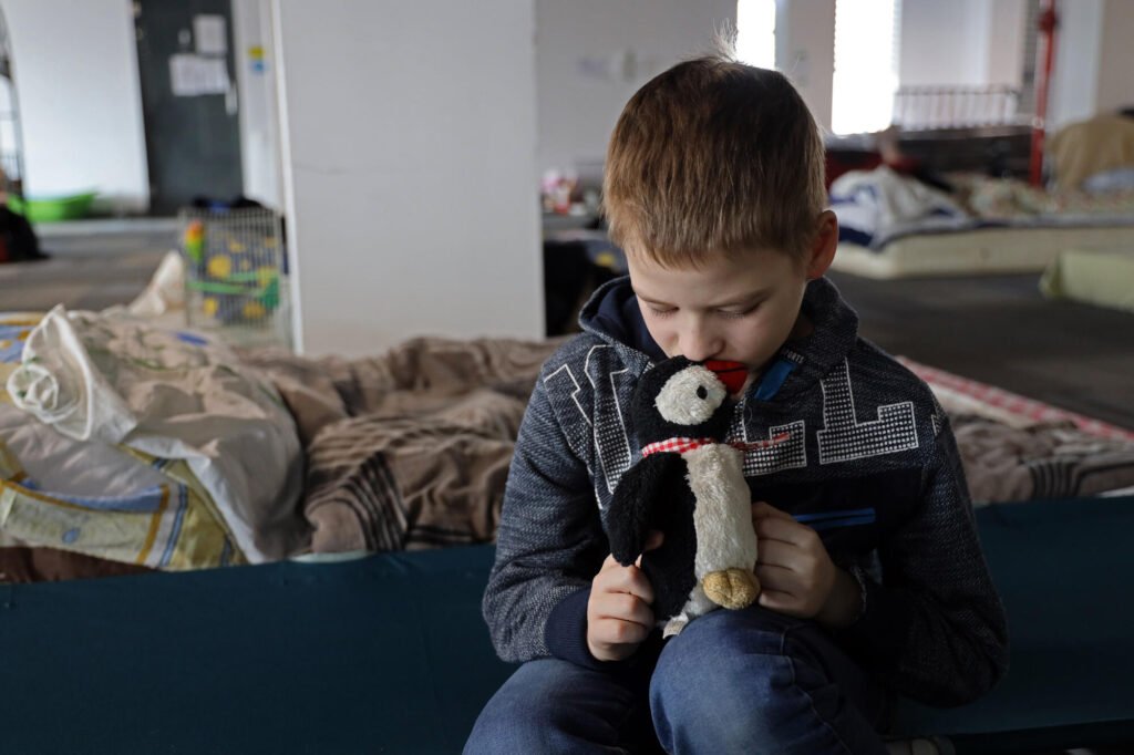 Ukrainalainen 8-vuotias Ivan katsoo vakavana ainoa leluaan, jota sai tuotua mukanaan kotoa. Lelu on pingviinipehmolelu.
