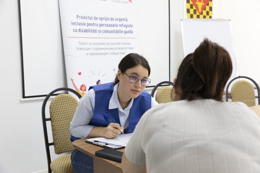 World Vision Moldivan työntekijä juttelee ukrainalaisen naisen kanssa.