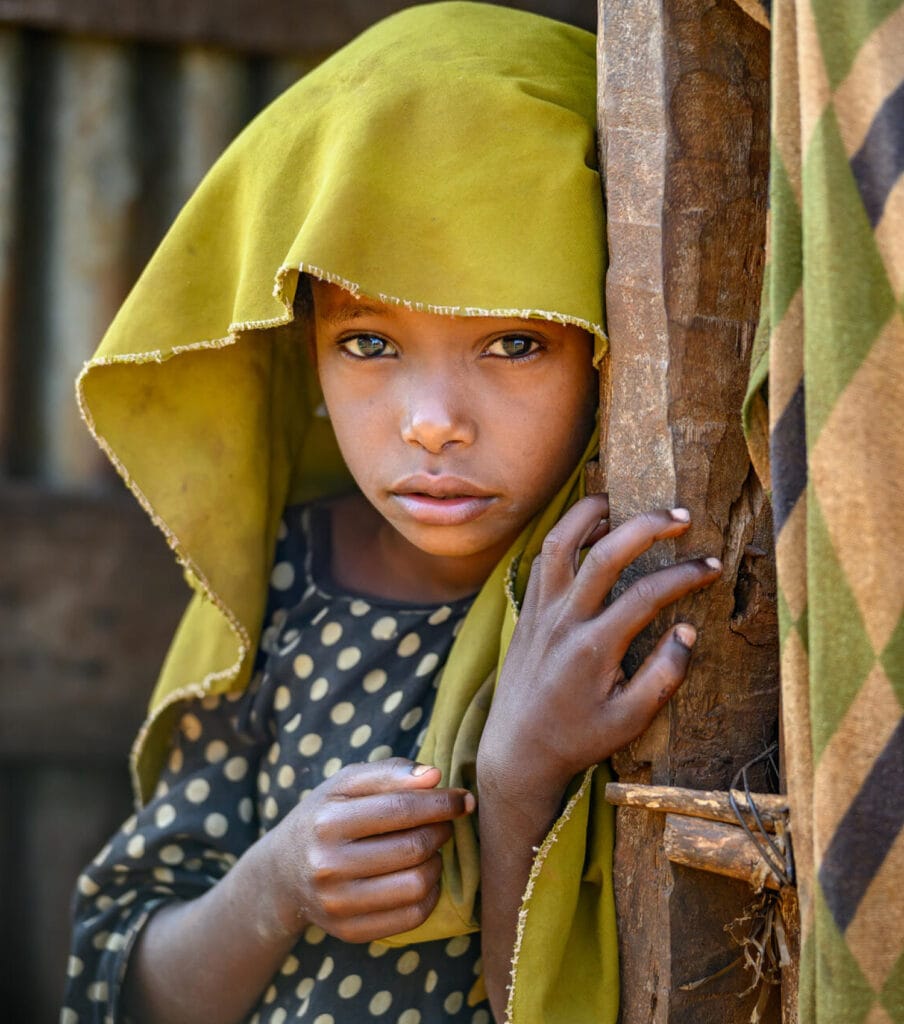 Etiopialaine tyttö katsoo vakavana kameraan.