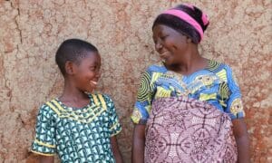 Kummilapsi Virginie ja hänen äitinsä ovat kotinsa pihalla Burundin maaseudulla.