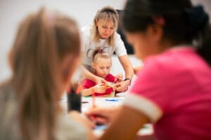 Ukrainalaisia lapsia ja opettaja koulussa askartelemassa