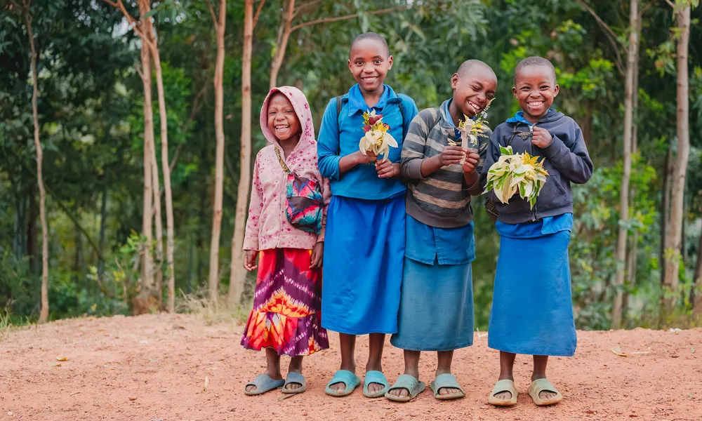 Neljä lasta nauravat vierekkäin.